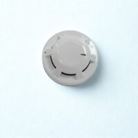 Top-down view of a white Apollo Orbis Marine Optical Smoke Detector mounted on a light surface, featuring its signature low-profile aerodynamic design and smoke entry ports