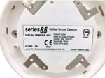 Rear view of Apollo 55000-316APO smoke detector showing the technical label with EN54-7 certification, 9-33V DC supply range, and manufacturer details