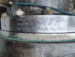 Close-up of engraved pressure ratings and identification numbers on the machined metal flange of an Atlas Copco GT-026-T1K1 centrifugal compressor.