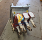 Top-down angled view of the three-phase red insulated pole assemblies and contact arms on an ABB HD4.W 12.12.32 vacuum SF6 breaker.