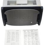 Front view of the Aeroflex TM500 test unit featuring a grey protective faceplate with a power button, accompanied by printed instruction manuals laid out in front