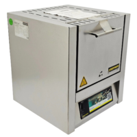 Front view of a stainless steel Nabertherm L 5/11 laboratory muffle furnace with digital program controller interface and original operator manual on a white countertop.