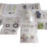 Sorted and individually bagged replacement parts and maintenance kit components for Clover Tool C54450-51 fluid end pump spares arranged against a black background.