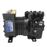 Full side profile view of the black Copeland KAM1-010A-TAD-800 semi-hermetic reciprocating compressor showing mounting feet base, central heat dissipation ribs, and blue spec plate location.