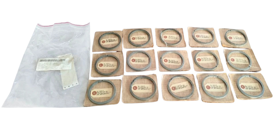 Micarta Piston Rings 269-312232-999 Lot of 15 new surplus Micarta piston rings part number 269-312232-999 for 3-1/2 inch bore industrial compressors, displayed on cardboard backing next to their original protective plastic packaging.