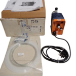 Complete ProMinent Beta 4 pump package including pump unit, original cardboard box, tubing coil, foot valve, and instruction manuals.