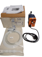 Complete ProMinent Beta 4 pump package including pump unit, original cardboard box, tubing coil, foot valve, and instruction manuals.