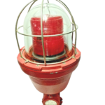 Sirena EX 0100 STL L explosion-proof industrial visual signaling beacon featuring a heavy-duty red aluminum base, a clear borosilicate glass outer dome protected by a stainless steel wire guard cage, and an internal red Fresnel lens.