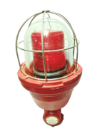 Sirena EX 0100 STL L explosion-proof industrial visual signaling beacon featuring a heavy-duty red aluminum base, a clear borosilicate glass outer dome protected by a stainless steel wire guard cage, and an internal red Fresnel lens.
