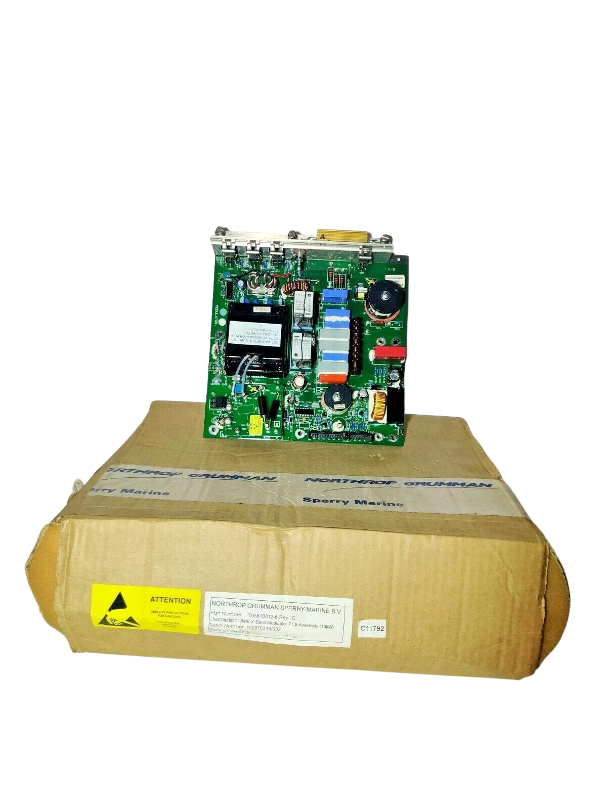 Sperry Marine T65810812-6 New Sperry Marine T65810812-6 Rev C 10KW Modulator PCB resting on an original Northrop Grumman factory cardboard box with visible serial number labels.