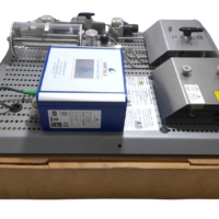 Side view of the reconditioned Wartsila 350753 Oxygen Analyzer module resting on a shipping box, detailing the internal piping, wiring connectors, and hot surface warning shields.