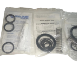 New Williams Milton Roy P1000V pump repair kit parts, including o-rings, plunger seals, and grease tube, in sealed packaging.