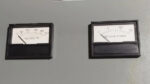 Close-up view of DC Volts and DC Amperes analog display meters on a LaMarche battery charger unit.